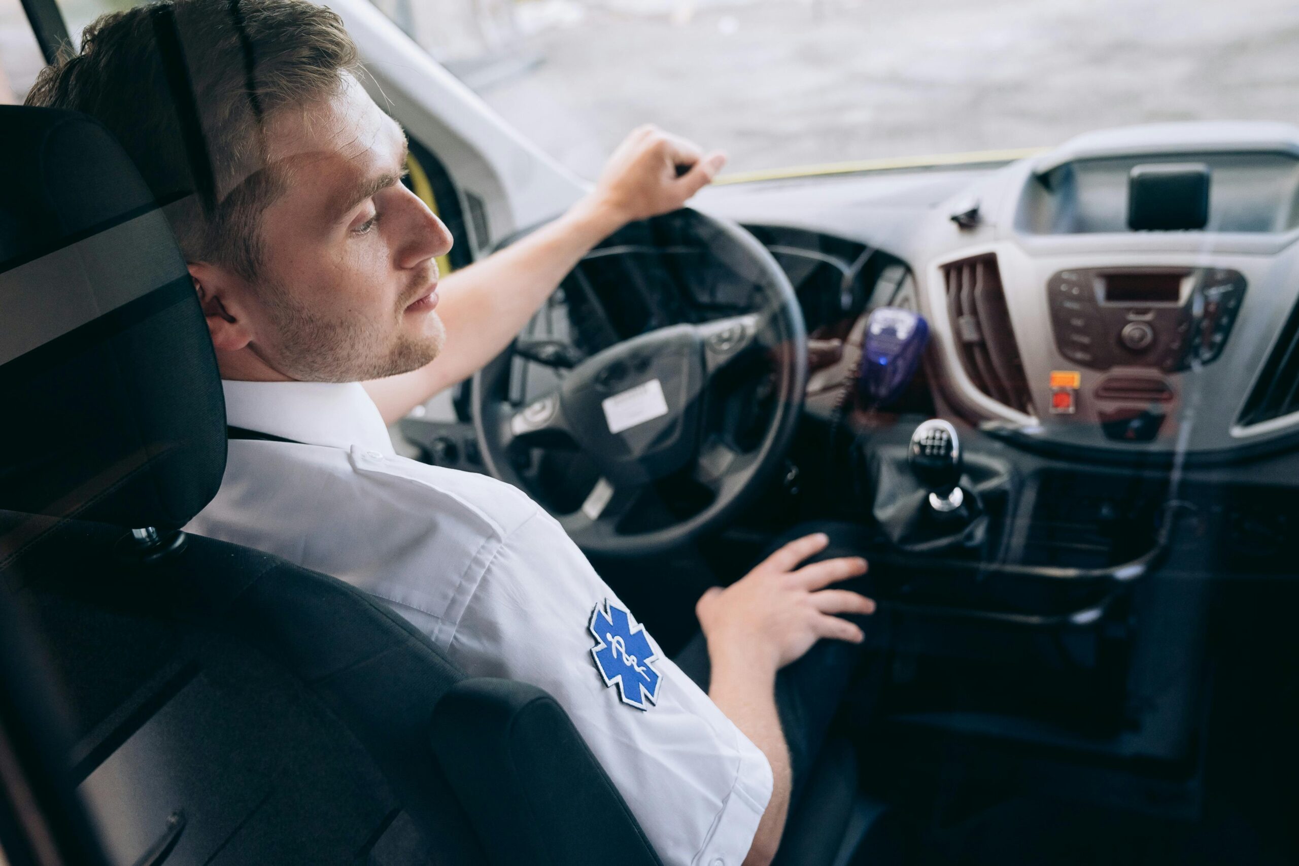 Ambulance driver focused on the road in an emergency vehicle, showcasing urgency and professionalism.